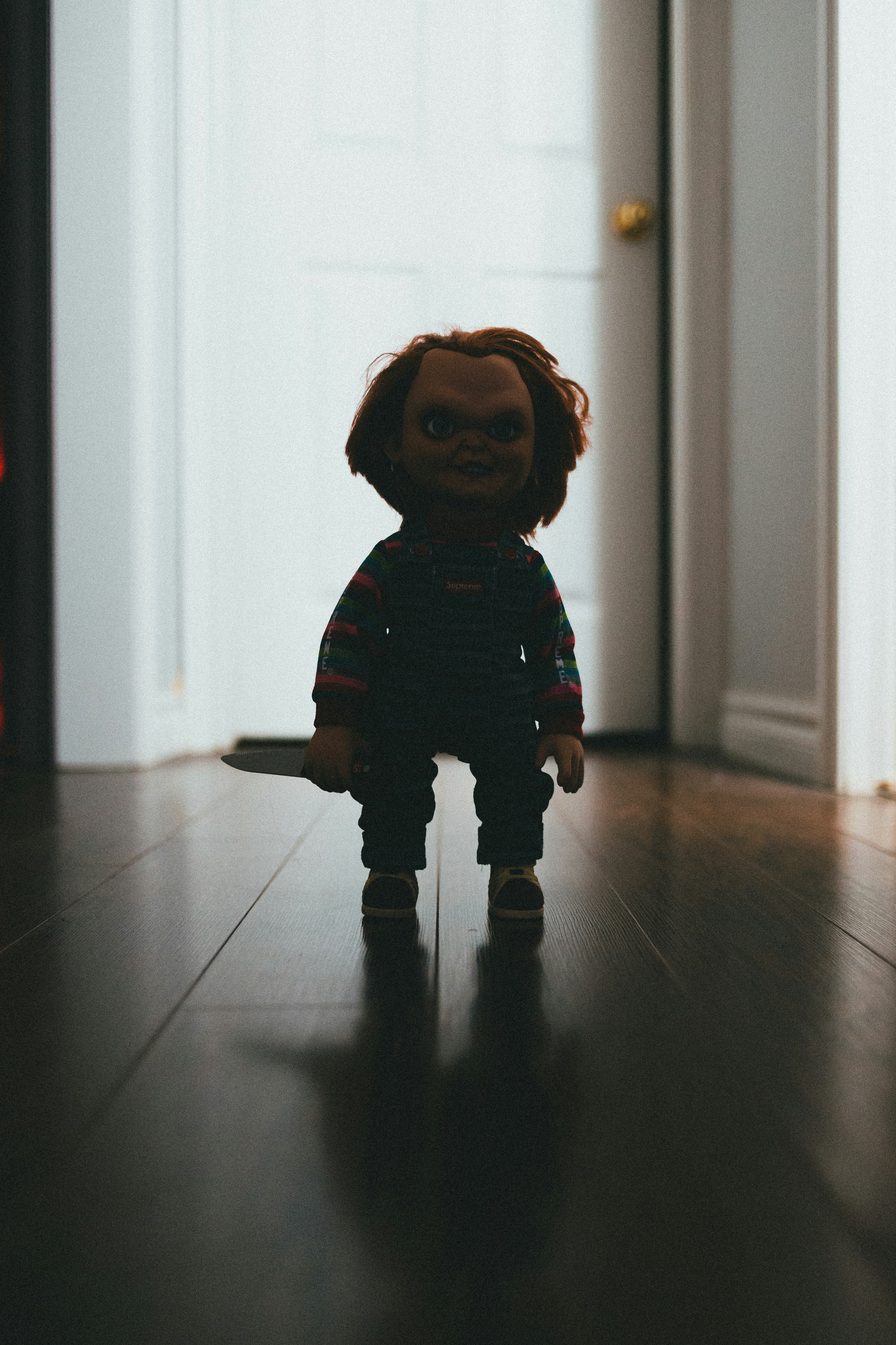 child in blue and red plaid dress shirt standing on brown floor tiles